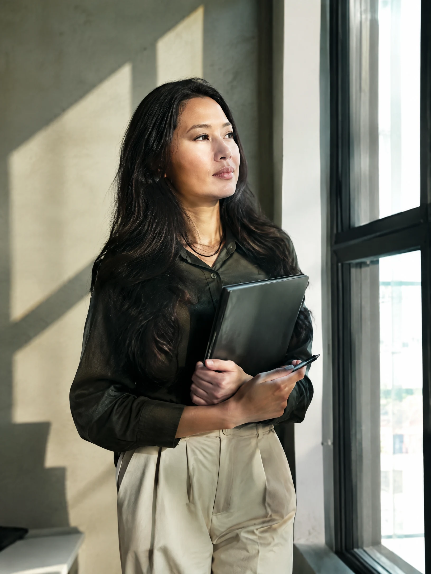Professional reflecting by a window
